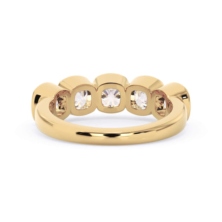 A picture of a five stone diamond wedding ring with cushion shape diamonds that are bezel set in yellow gold on a white background with a view of the underside of the ring.