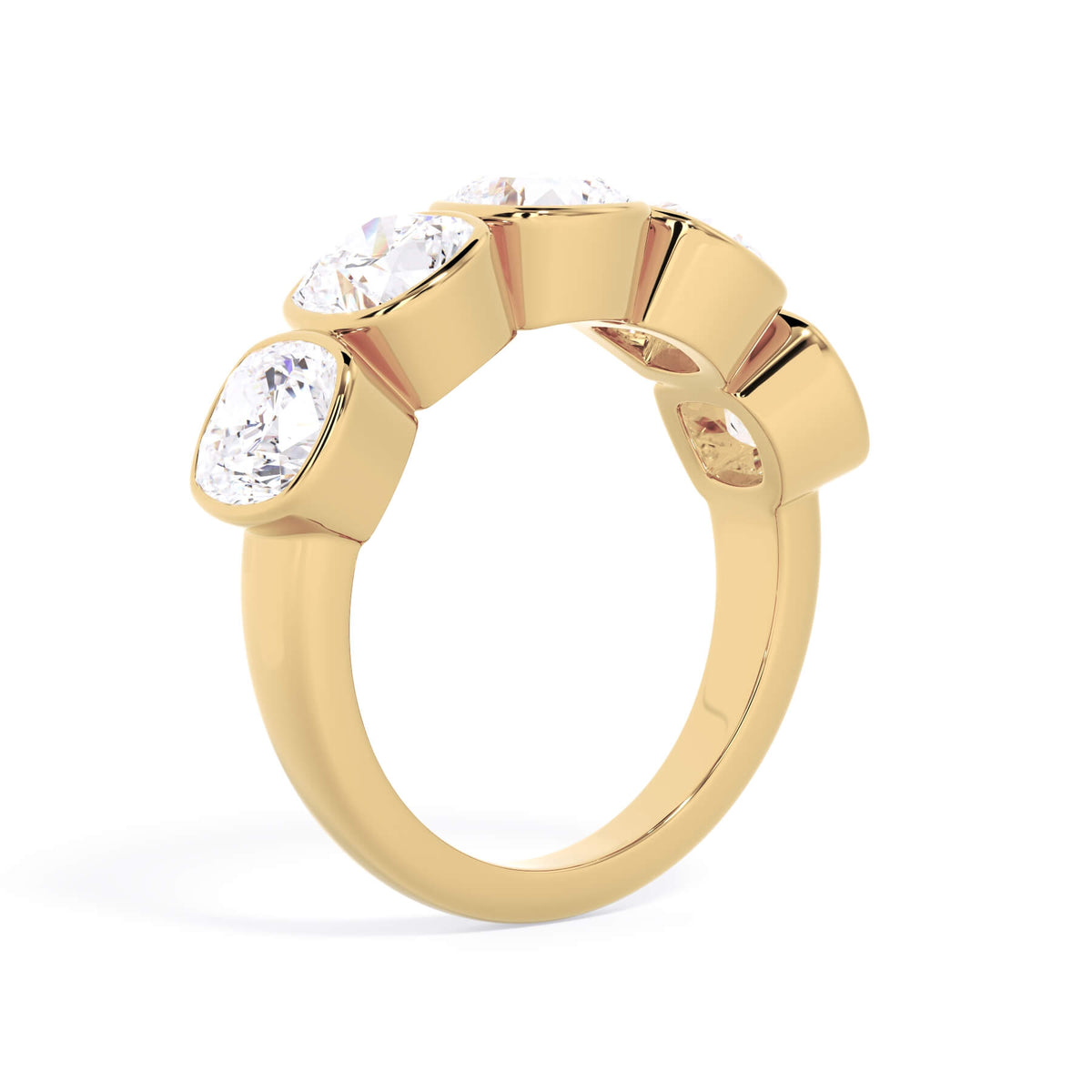 A picture of a five stone diamond wedding ring with cushion shape diamonds that are bezel set in yellow gold on a white background with a slightly angled, through the finger view.