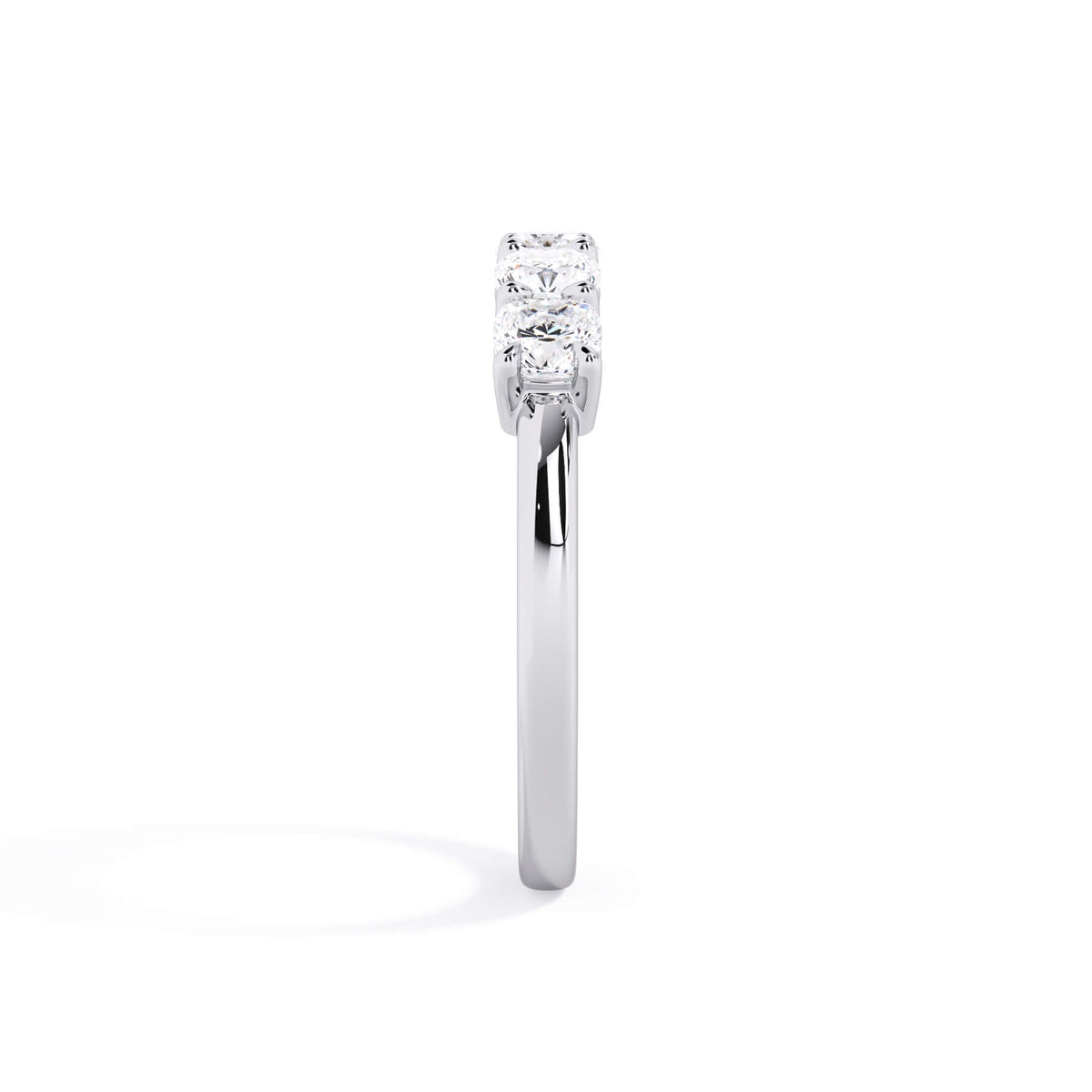 A picture of a five stone diamond wedding ring with cushion shape diamonds that are shared prong set in white gold or platinum on a white background with a side profile view.