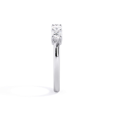 A picture of a five stone diamond wedding ring with cushion shape diamonds that are shared prong set in white gold or platinum on a white background with a side profile view.