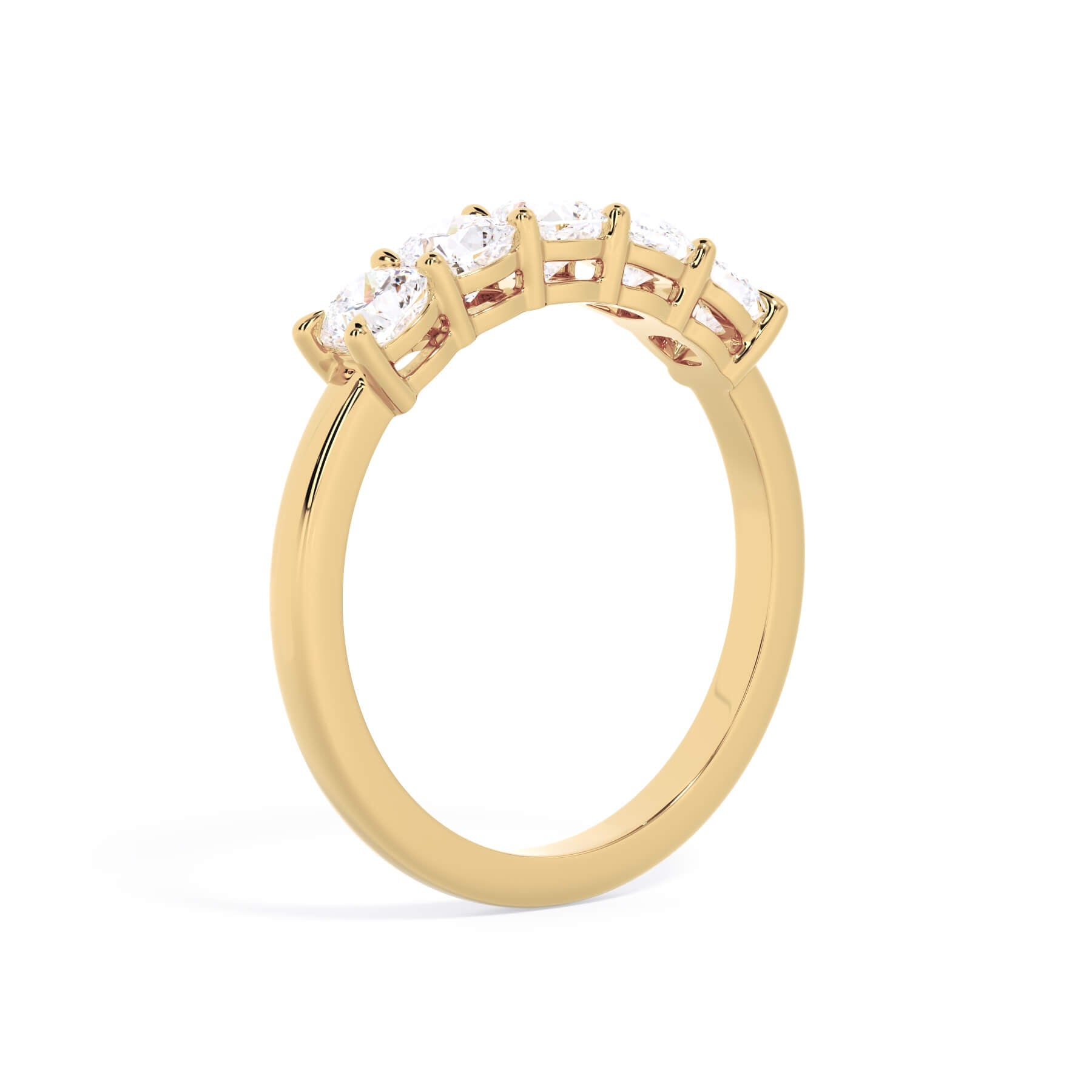 A picture of a five stone diamond wedding ring with cushion shape diamonds that are shared prong set in yellow gold on a white background with a slightly angled, through the finger view.