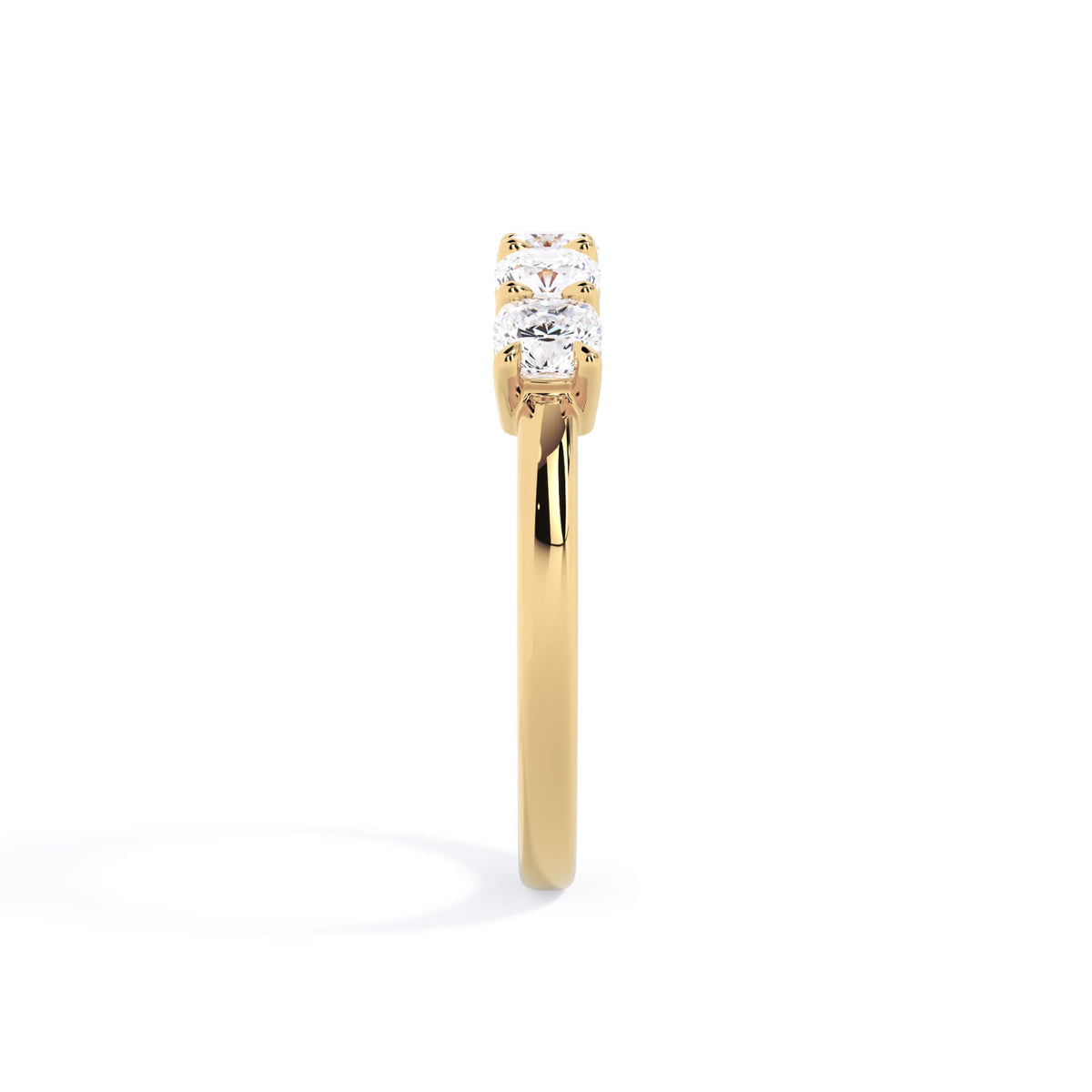 A picture of a five stone diamond wedding ring with cushion shape diamonds that are shared prong set in yellow gold on a white background with a side profile view.