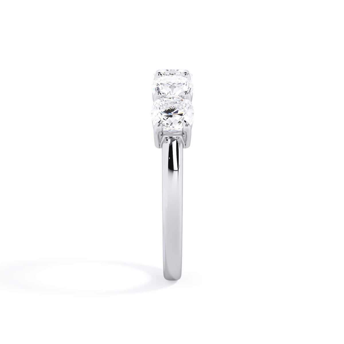 A picture of a five stone diamond wedding ring with cushion shape diamonds that are shared prong set in white gold or platinum on a white background with a side profile view.