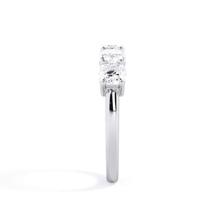 A picture of a five stone diamond wedding ring with cushion shape diamonds that are shared prong set in white gold or platinum on a white background with a side profile view.