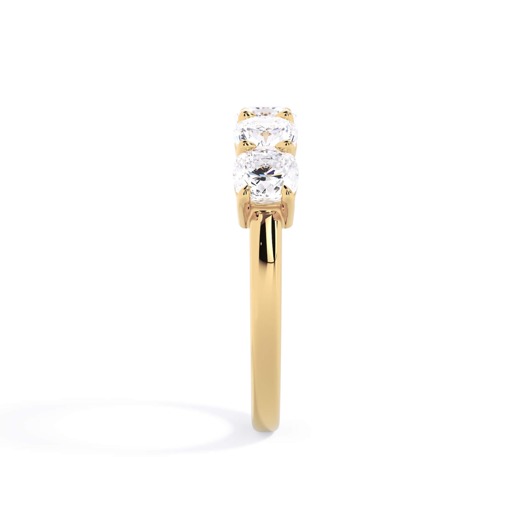 A picture of a five stone diamond wedding ring with cushion shape diamonds that are shared prong set in yellow gold on a white background with a side profile view.