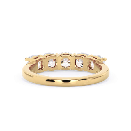 A picture of a five stone diamond wedding ring with cushion shape diamonds that are shared prong set in yellow gold on a white background with a view of the underside of the ring.