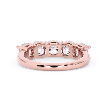 A picture of a five stone diamond wedding ring with cushion shape diamonds that are shared prong set in rose gold on a white background with a view of the underside of the ring.