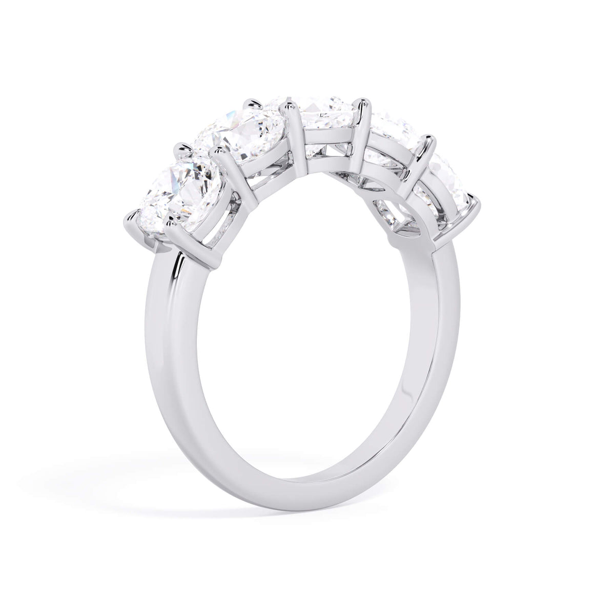 A picture of a five stone diamond wedding ring with cushion shape diamonds that are shared prong set in white gold or platinum on a white background with a slightly angled, through the finger view.
