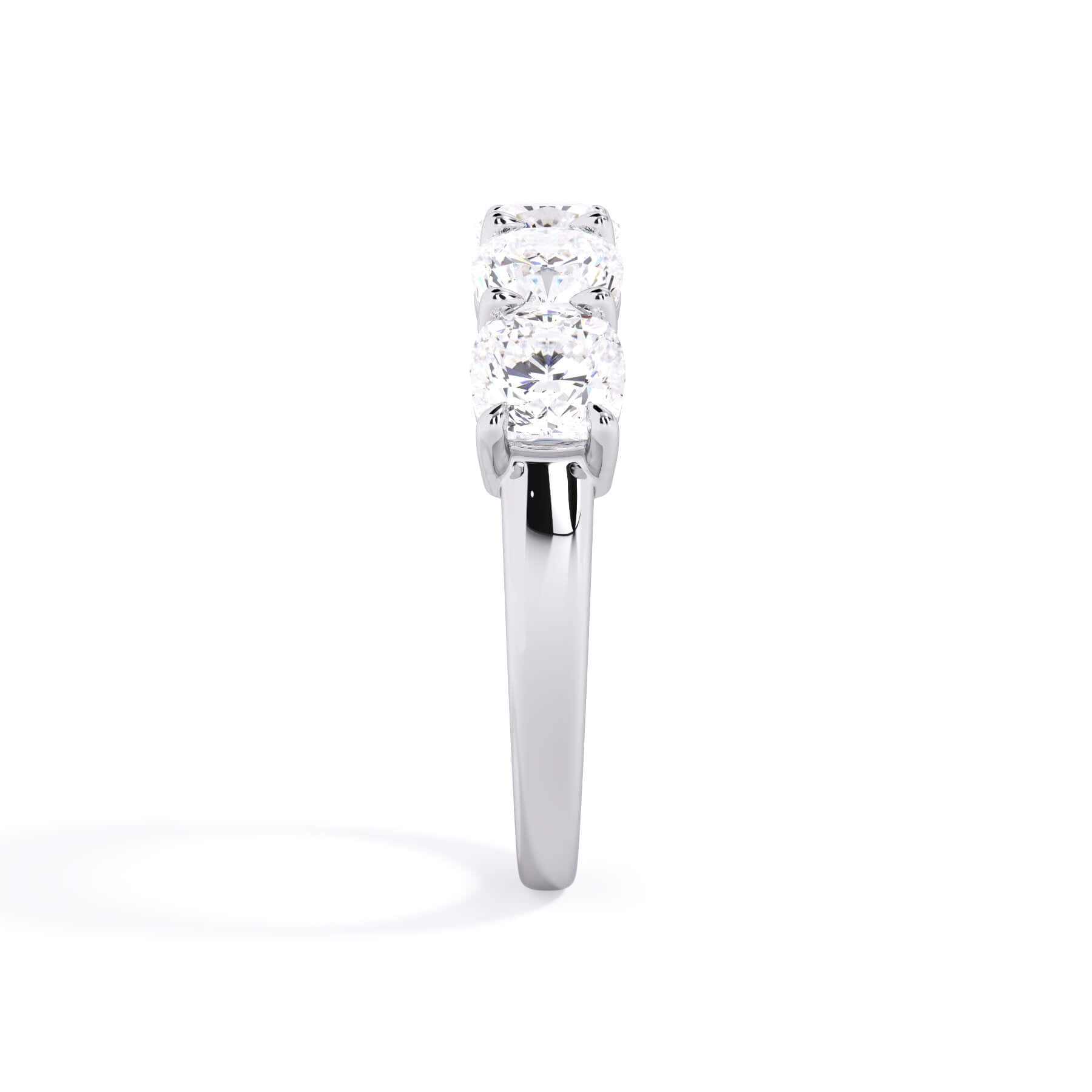 A picture of a five stone diamond wedding ring with cushion shape diamonds that are shared prong set in white gold or platinum on a white background with a side profile view.