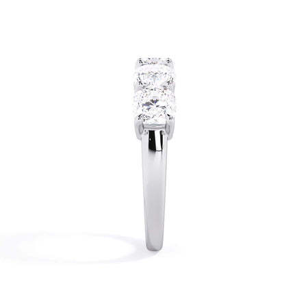 A picture of a five stone diamond wedding ring with cushion shape diamonds that are shared prong set in white gold or platinum on a white background with a side profile view.