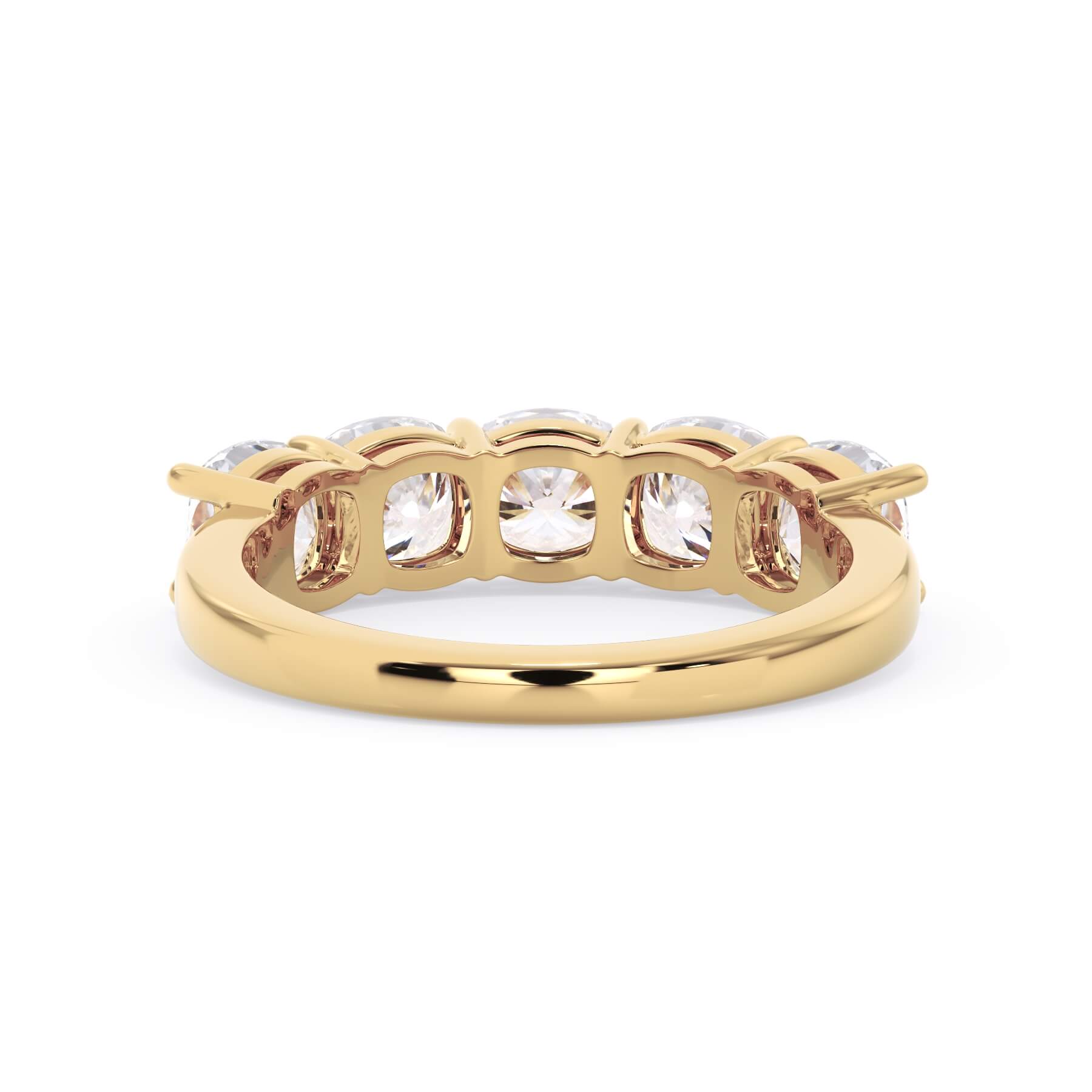 A picture of a five stone diamond wedding ring with cushion shape diamonds that are shared prong set in yellow gold on a white background with a view of the underside of the ring.