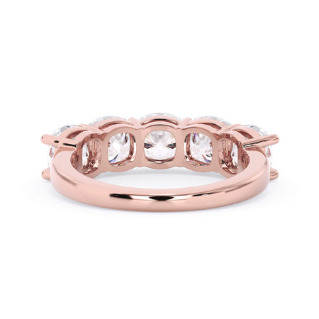 A picture of a five stone diamond wedding ring with cushion shape diamonds that are shared prong set in rose gold on a white background with a view of the underside of the ring.