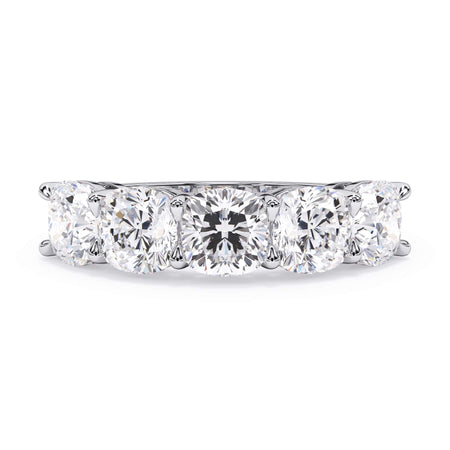 A picture of a five stone diamond wedding ring with cushion shape diamonds that are shared prong set in white gold or platinum on a white background with the ring facing forward, lying down.