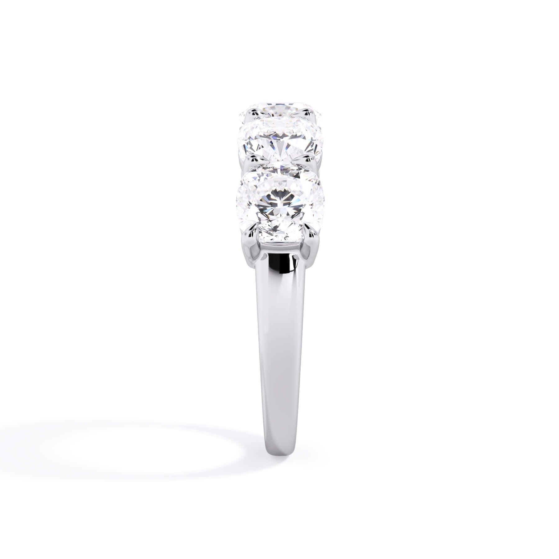 A picture of a five stone diamond wedding ring with cushion shape diamonds that are shared prong set in white gold or platinum on a white background with a side profile view.