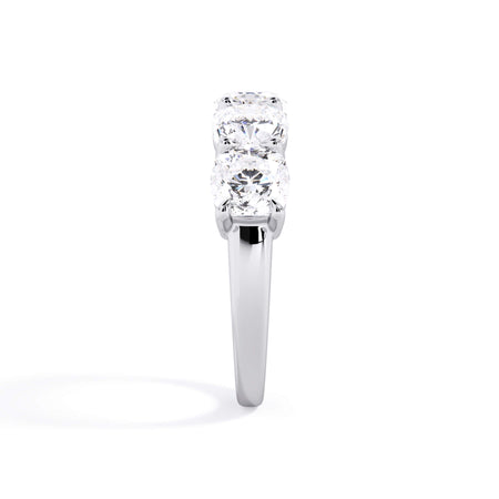 A picture of a five stone diamond wedding ring with cushion shape diamonds that are shared prong set in white gold or platinum on a white background with a side profile view.