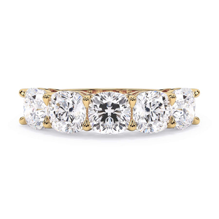 A picture of a five stone diamond wedding ring with cushion shape diamonds that are shared prong set in yellow gold on a white background with the ring facing forward, lying down.
