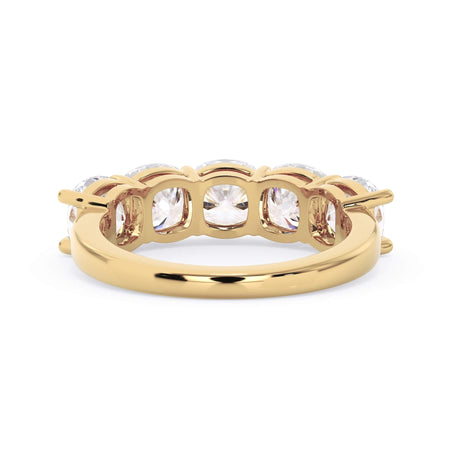 A picture of a five stone diamond wedding ring with cushion shape diamonds that are shared prong set in yellow gold on a white background with a view of the underside of the ring.