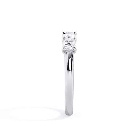 A picture of a five stone diamond wedding ring with cushion shape diamonds that are u prong set in white gold or platinum on a white background with a side profile view.