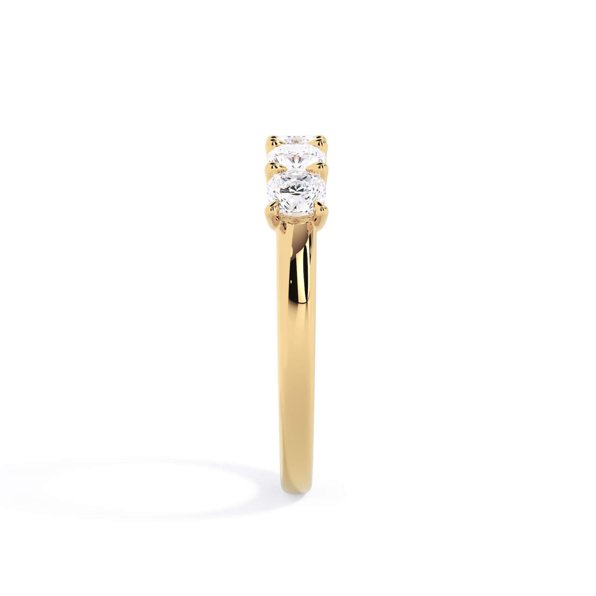 A picture of a five stone diamond wedding ring with cushion shape diamonds that are u prong set in yellow gold on a white background with a side profile view.