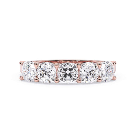 A picture of a five stone diamond wedding ring with cushion shape diamonds that are u prong set in rose gold on a white background with the ring facing forward, lying down.