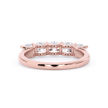 A picture of a five stone diamond wedding ring with cushion shape diamonds that are u prong set in rose gold on a white background with a view of the underside of the ring.