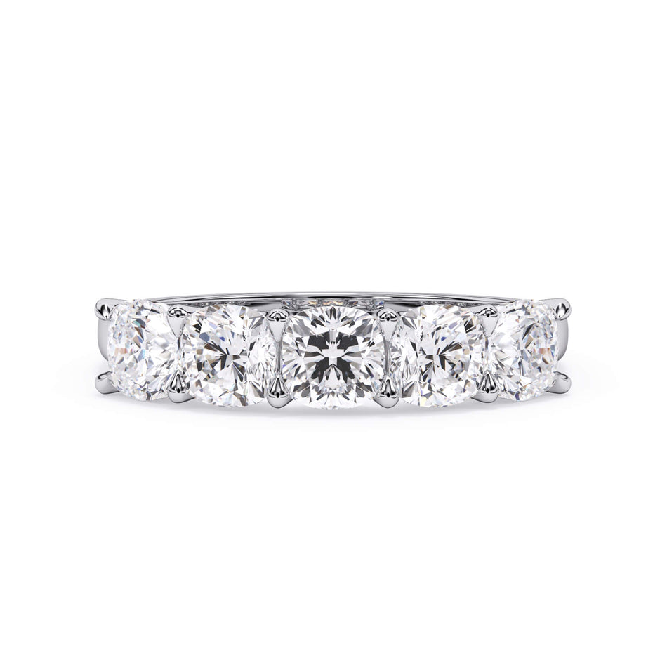 A picture of a five stone diamond wedding ring with cushion shape diamonds that are u prong set in white gold or platinum on a white background with the ring facing forward, lying down.