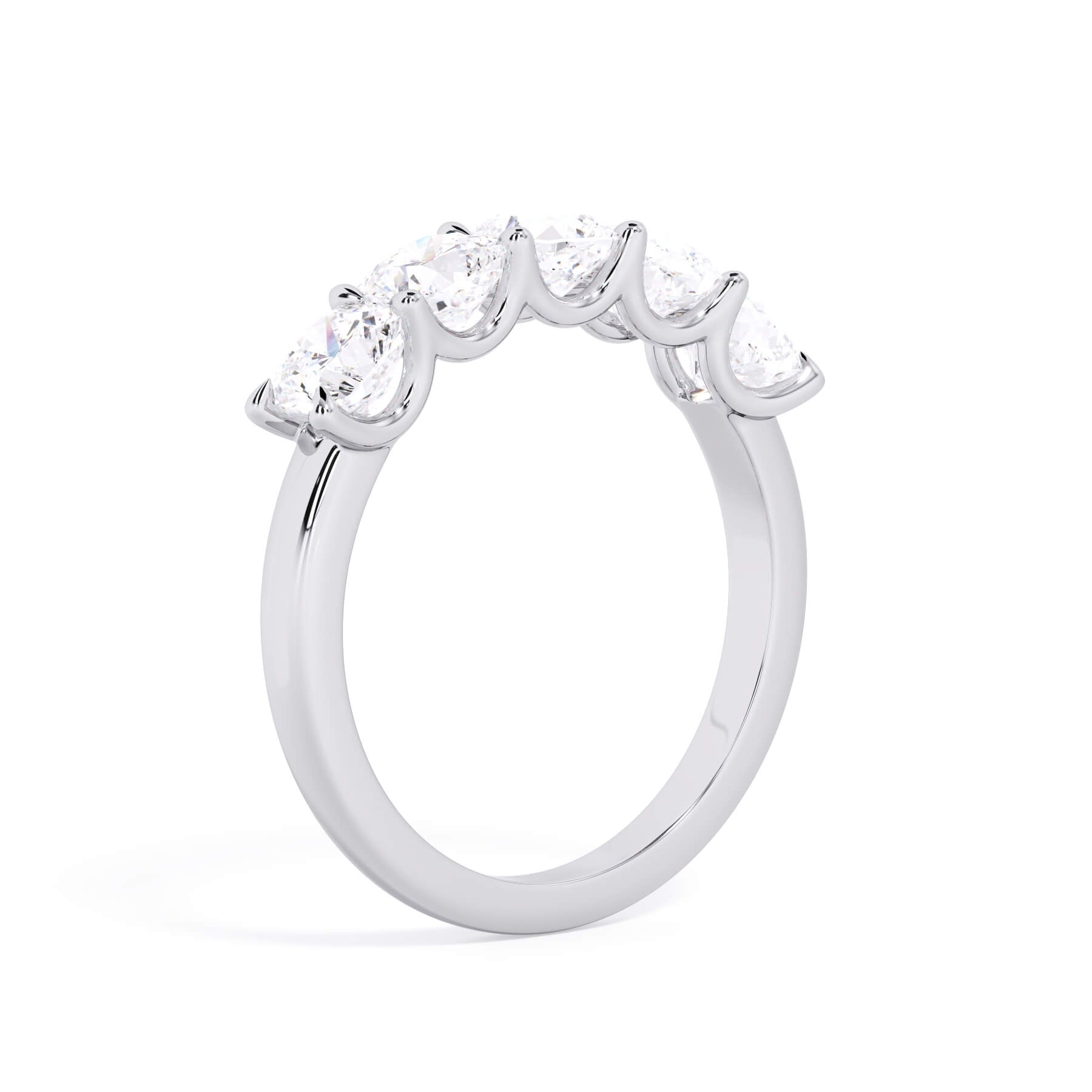 A picture of a five stone diamond wedding ring with cushion shape diamonds that are u prong set in white gold or platinum on a white background with a slightly angled, through the finger view.
