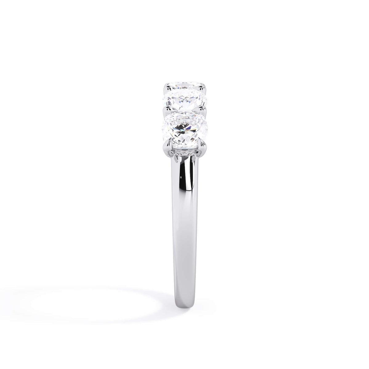 A picture of a five stone diamond wedding ring with cushion shape diamonds that are u prong set in white gold or platinum on a white background with a side profile view.