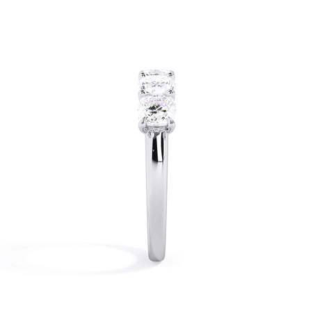 A picture of a five stone diamond wedding ring with cushion shape diamonds that are u prong set in white gold or platinum on a white background with a side profile view.