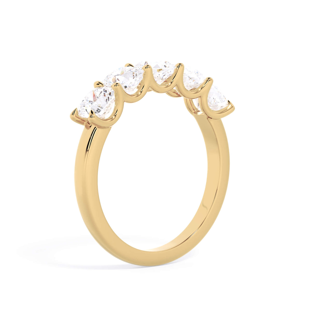 A picture of a five stone diamond wedding ring with cushion shape diamonds that are u prong set in yellow gold on a white background with a slightly angled, through the finger view.