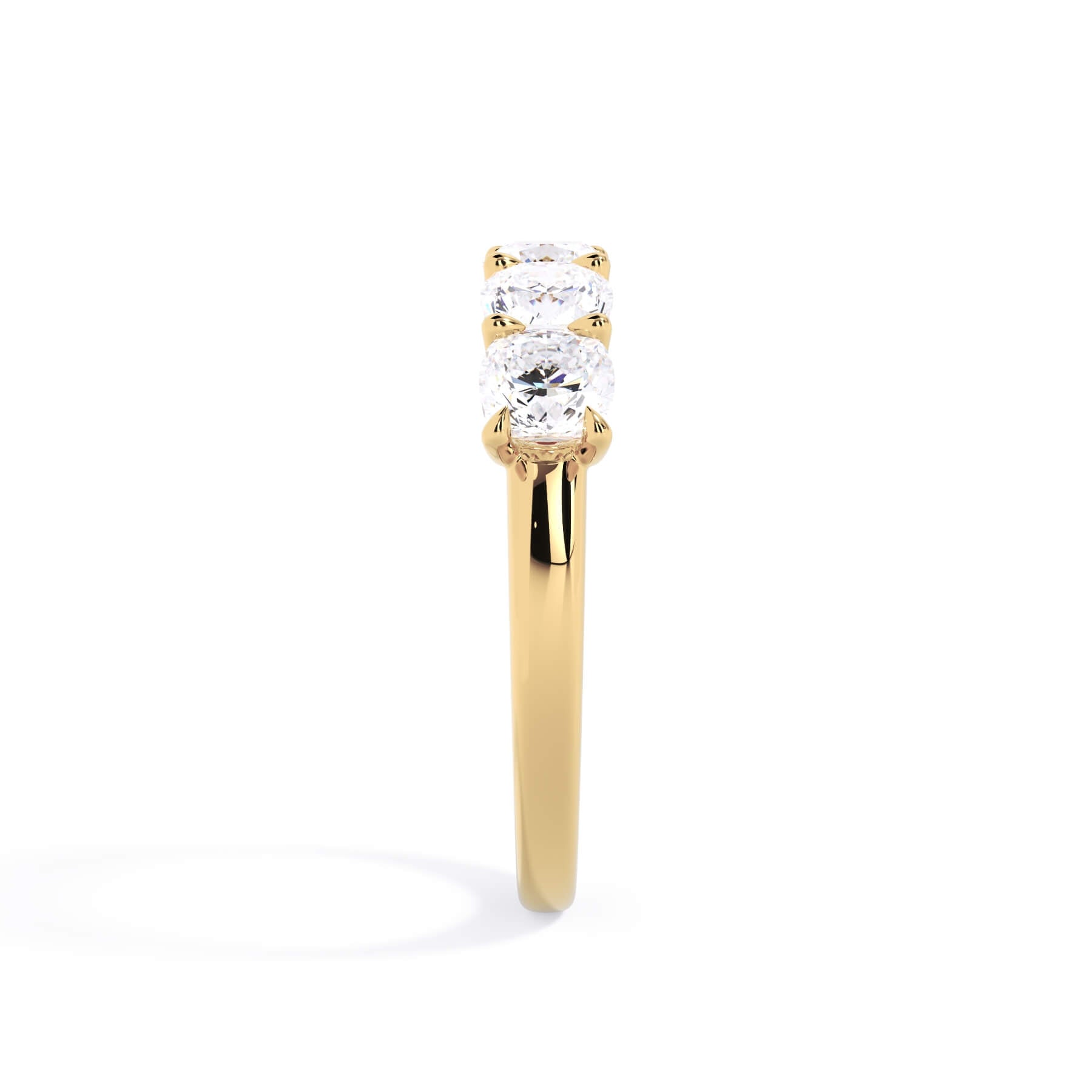 A picture of a five stone diamond wedding ring with cushion shape diamonds that are u prong set in yellow gold on a white background with a side profile view.