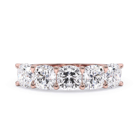 A picture of a five stone diamond wedding ring with cushion shape diamonds that are u prong set in rose gold on a white background with the ring facing forward, lying down.