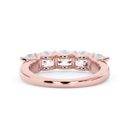 A picture of a five stone diamond wedding ring with cushion shape diamonds that are u prong set in rose gold on a white background with a view of the underside of the ring.