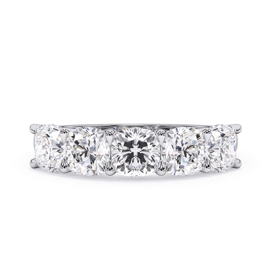 A picture of a five stone diamond wedding ring with cushion shape diamonds that are u prong set in white gold or platinum on a white background with the ring facing forward, lying down.