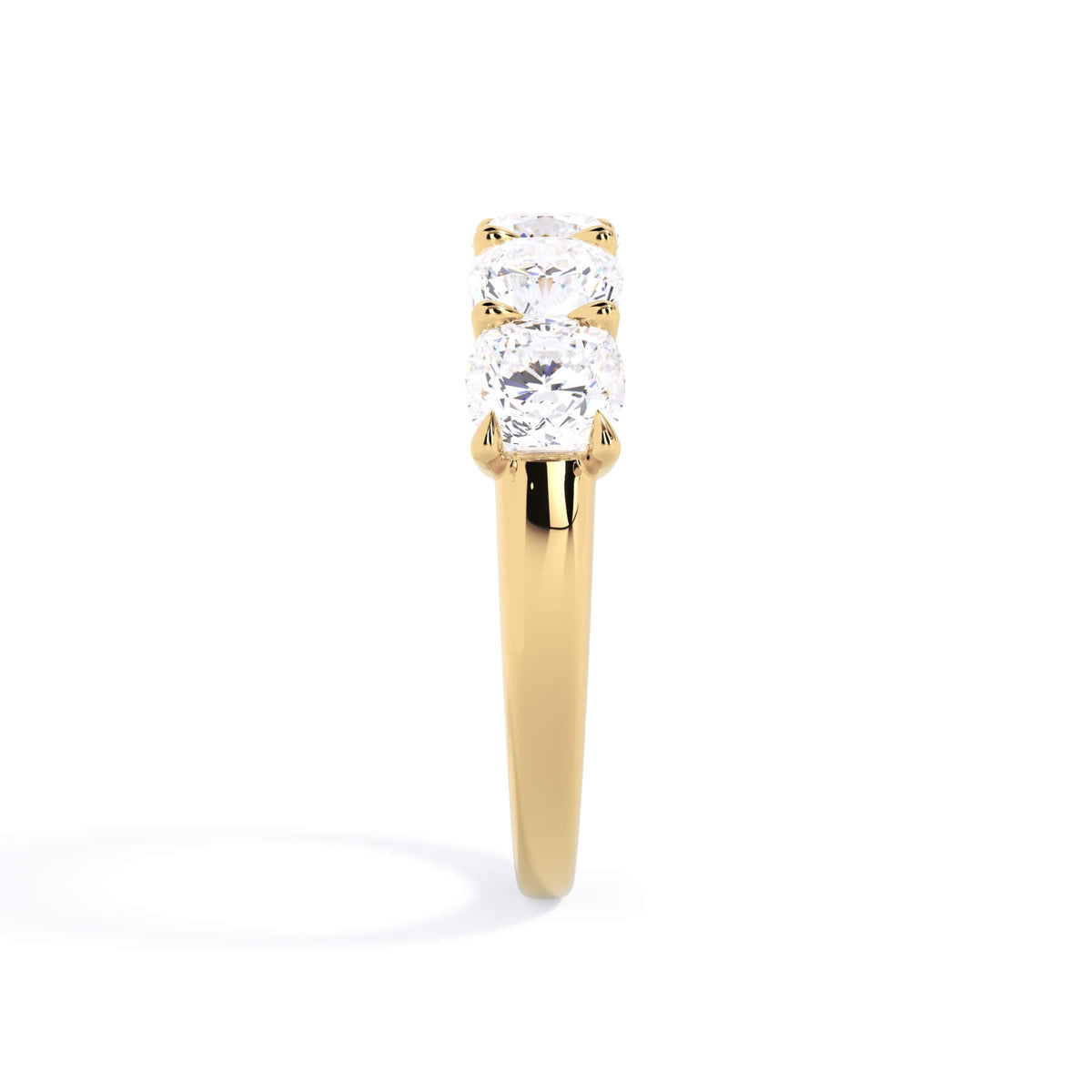 A picture of a five stone diamond wedding ring with cushion shape diamonds that are u prong set in yellow gold on a white background with a side profile view.