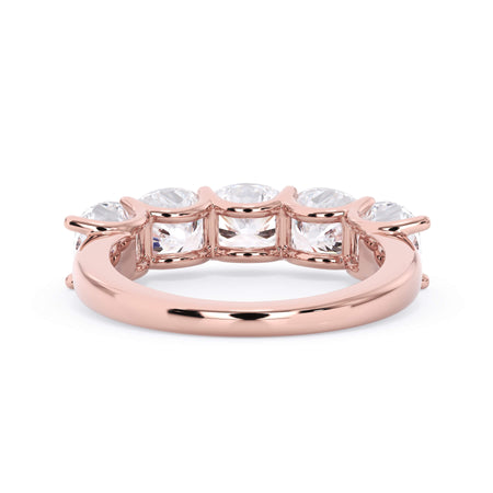 A picture of a five stone diamond wedding ring with cushion shape diamonds that are u prong set in rose gold on a white background with a view of the underside of the ring.