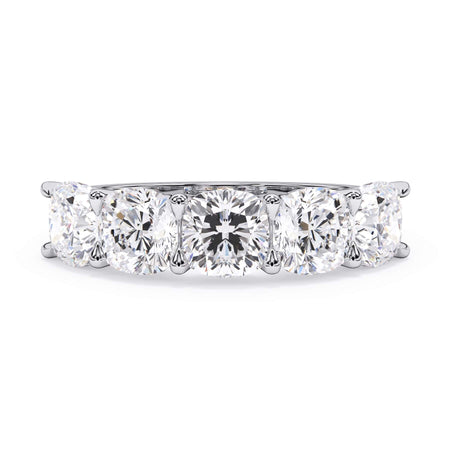 A picture of a five stone diamond wedding ring with cushion shape diamonds that are u prong set in white gold or platinum on a white background with the ring facing forward, lying down.