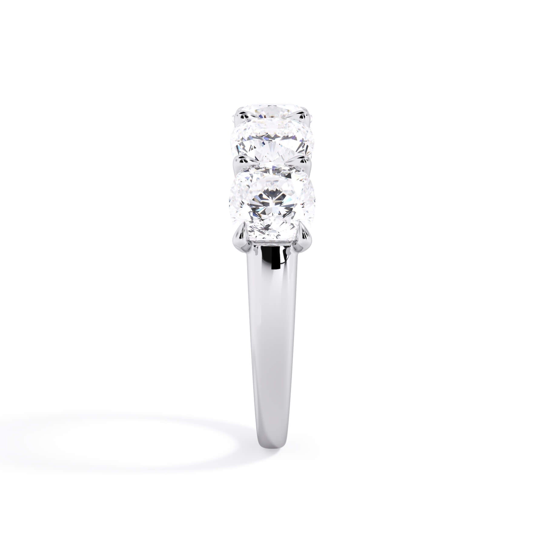 A picture of a five stone diamond wedding ring with cushion shape diamonds that are u prong set in white gold or platinum on a white background with a side profile view.