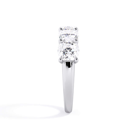 A picture of a five stone diamond wedding ring with cushion shape diamonds that are u prong set in white gold or platinum on a white background with a side profile view.