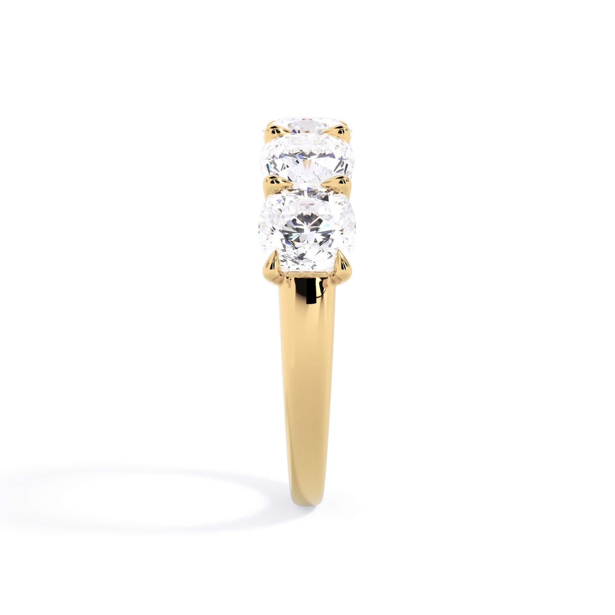 A picture of a five stone diamond wedding ring with cushion shape diamonds that are u prong set in yellow gold on a white background with a side profile view.