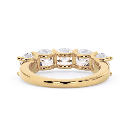 A picture of a five stone diamond wedding ring with cushion shape diamonds that are u prong set in yellow gold on a white background with a view of the underside of the ring.