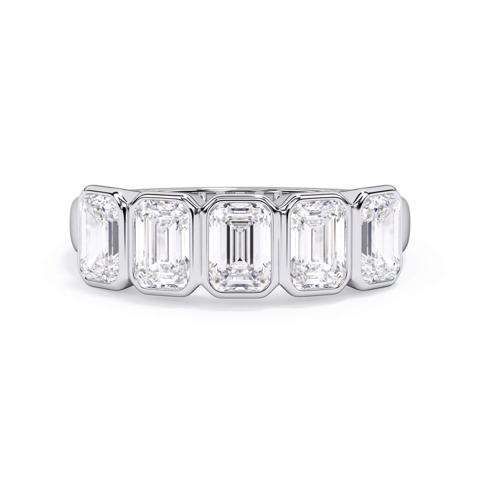 A picture of a five stone diamond wedding ring with emerald cut diamonds that are bezel set in white gold or platinum on a white background with the ring facing forward, lying down.