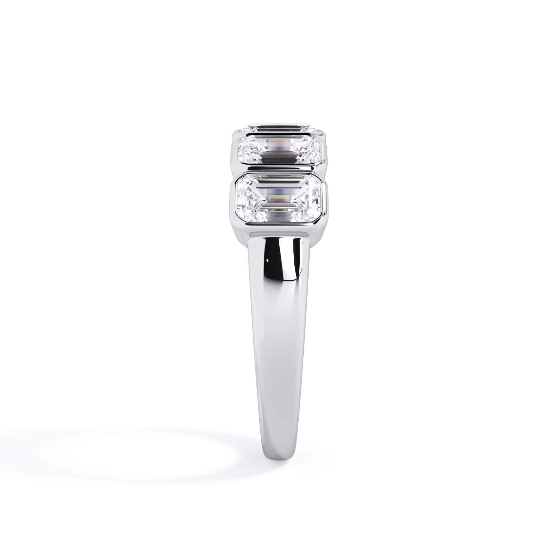A picture of a five stone diamond wedding ring with emerald cut diamonds that are bezel set in white gold or platinum on a white background with a side profile view.