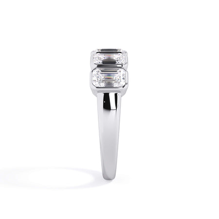 A picture of a five stone diamond wedding ring with emerald cut diamonds that are bezel set in white gold or platinum on a white background with a side profile view.