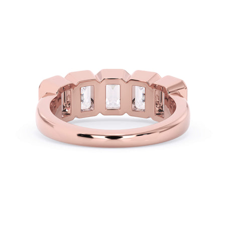 A picture of a five stone diamond wedding ring with emerald cut diamonds that are bezel set in rose gold on a white background with a view of the underside of the ring.
