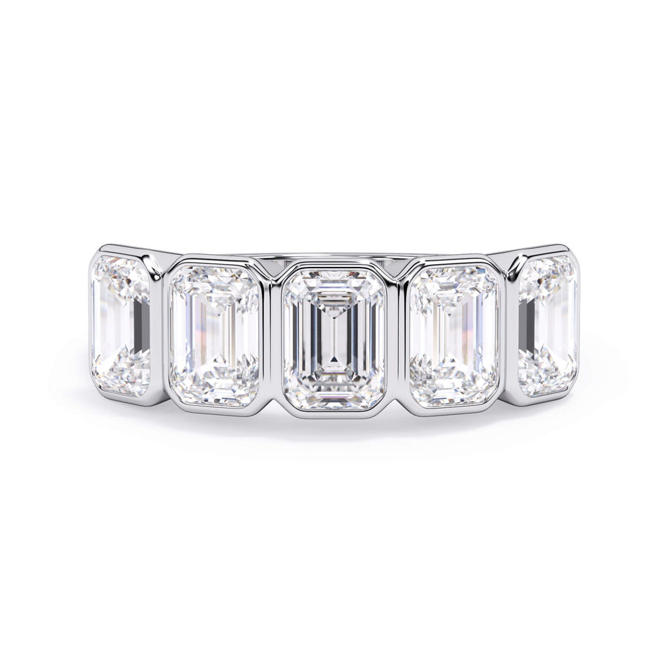 A picture of a five stone diamond wedding ring with emerald cut diamonds that are bezel set in white gold or platinum on a white background with the ring facing forward, lying down.