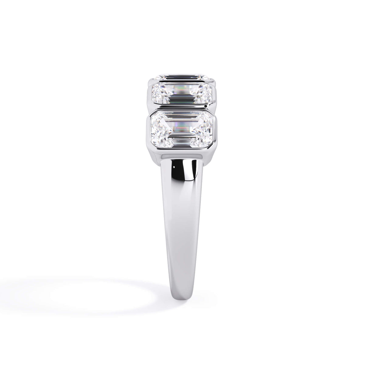 A picture of a five stone diamond wedding ring with emerald cut diamonds that are bezel set in white gold or platinum on a white background with a side profile view.