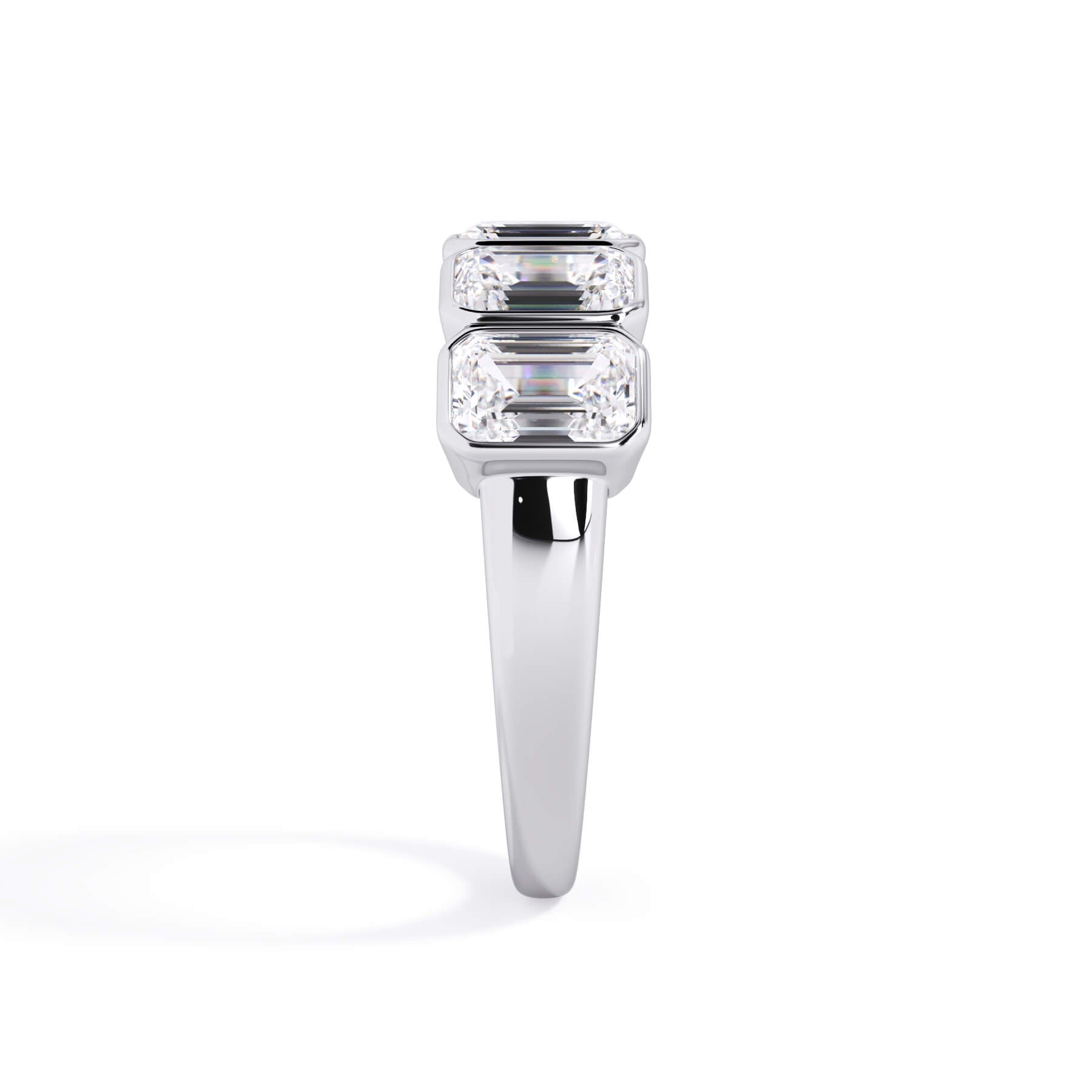 A picture of a five stone diamond wedding ring with emerald cut diamonds that are bezel set in white gold or platinum on a white background with a side profile view.