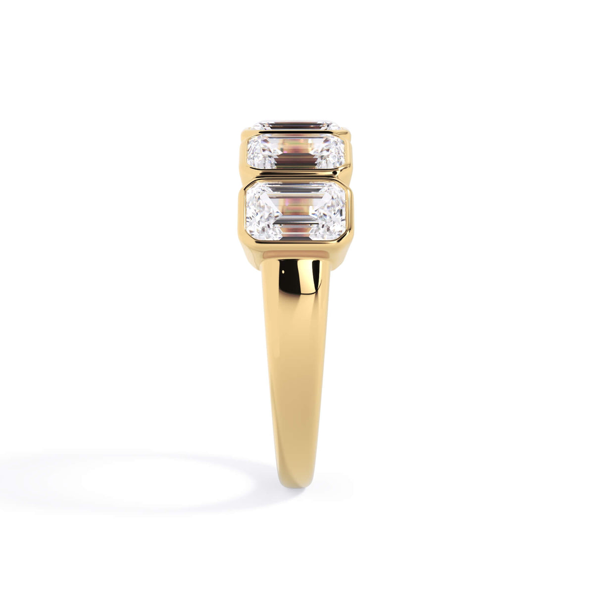 A picture of a five stone diamond wedding ring with emerald cut diamonds that are bezel set in yellow gold on a white background with a side profile view.