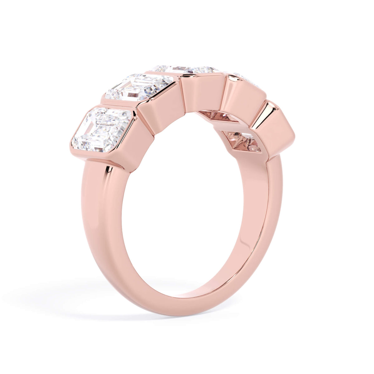 A picture of a five stone diamond wedding ring with emerald cut diamonds that are bezel set in rose gold on a white background with a slightly angled, through the finger view.